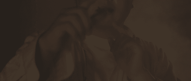 Man gesturing to take a photo in a dark place