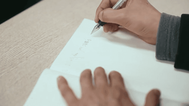 노트에 글을 쓰는 사람