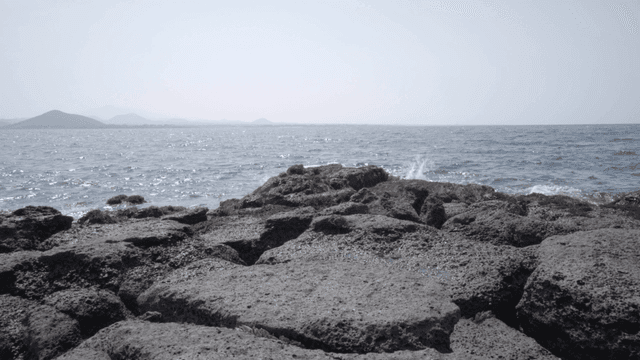 Rocky shore with waves under a clear sky