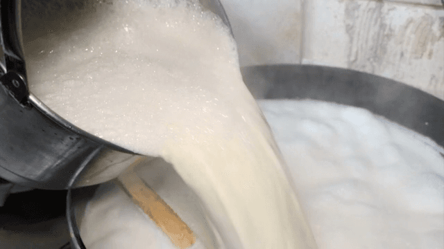 Pouring soybean soup into a boiling pot