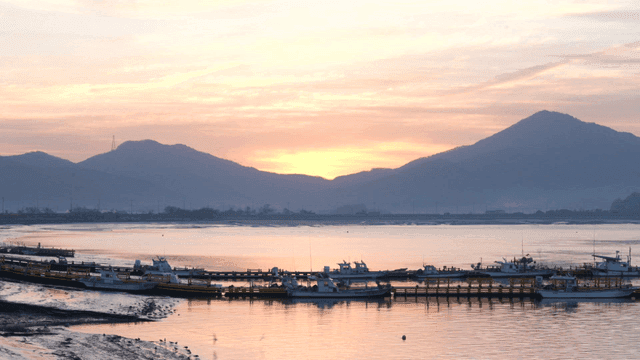 Sunset over a calm harbor with mountains