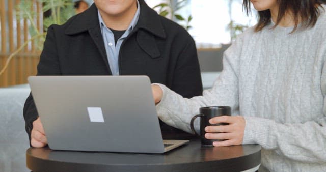 노트북 화면을 보고 의견을 나누는 동료들