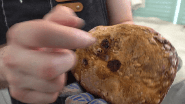 Baker tapping freshly baked campagne
