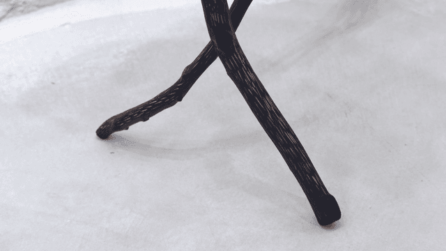 콘크리트 바닥 위의 나무 삼각대 다리