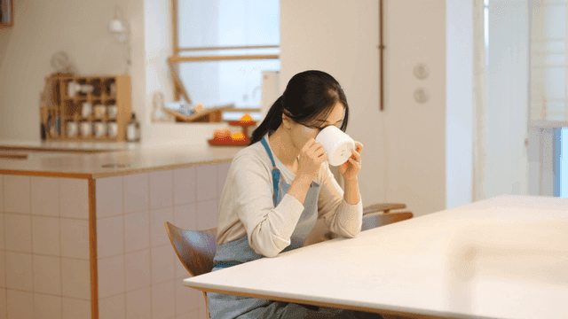 Woman drinking coffee at table