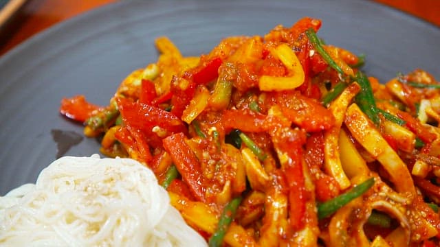 접시에 담긴 매콤한 오징어 초무침과 소면