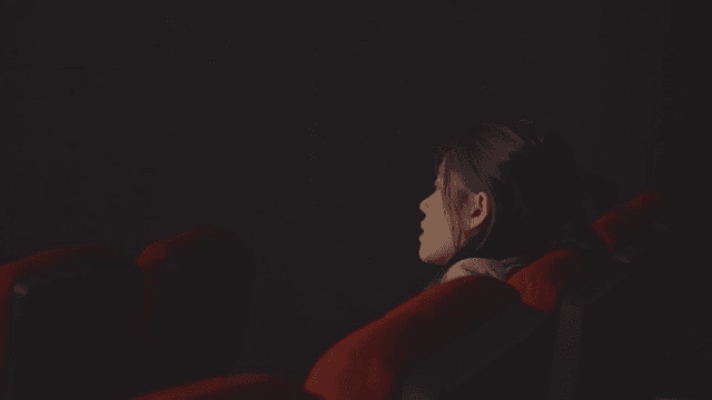 영화관 좌석에서 휴식을 취하는 여성