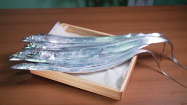 Freshly caught hairtail fish on a wooden tray