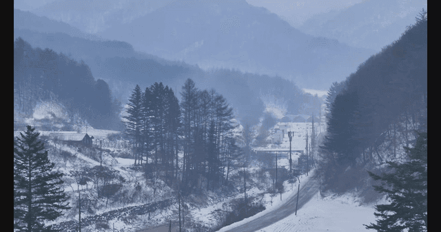 Snowy mountain village with winding road