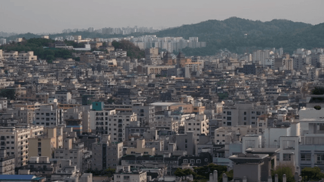 멀리 언덕이 보이는 밀집된 도시 풍경