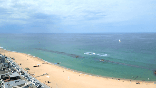 Serene beach with a distant yacht