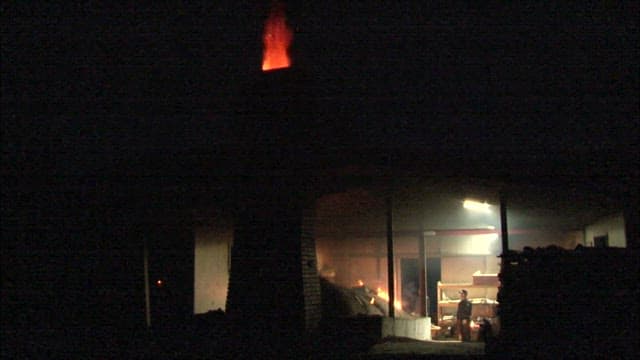 어두운 작업장에서 일하는 주조공