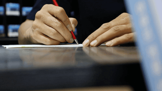 빨간 펜으로 글을 쓰는 사람