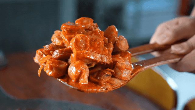 뜨거운 부대볶음을 가득 퍼낸 나무 주걱