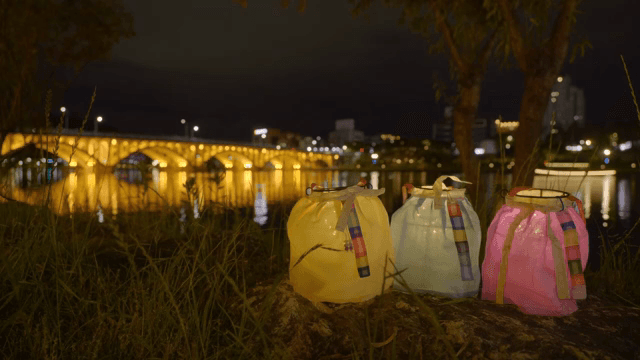 밤에 불이 켜진 다리 옆의 색색의 등불