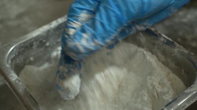 Hands scooping up flour