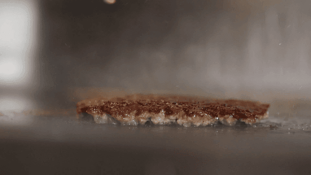 Burger patty sizzling on a hot grill