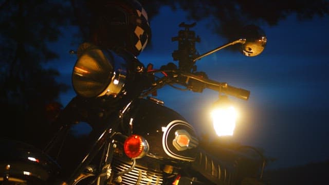 Motorcycle parked at night with headlights on