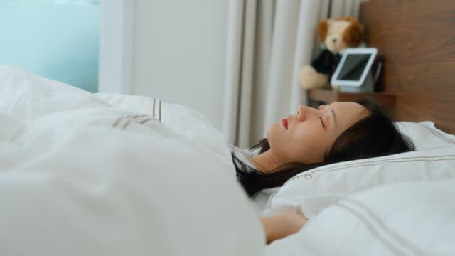 침대에서 잠을 자는 여자