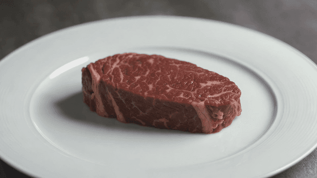 Raw steak on white plate