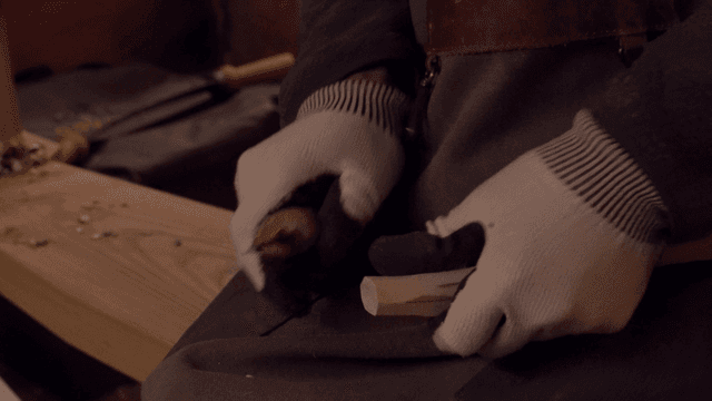 장인이 정교하게 나무를 조각하는 모습