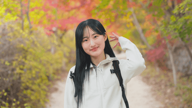가을 단풍길에서 미소 짓는 여자