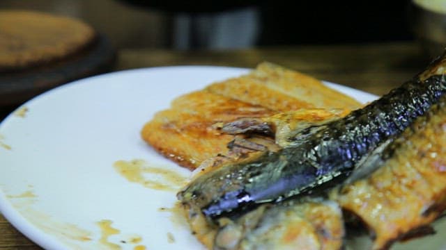 Grilled mackerel served on a white plate