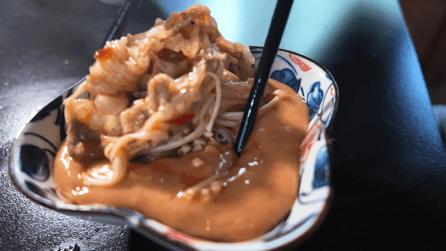 Chopsticks eating spicy cheese mala hotpot from boiling pot