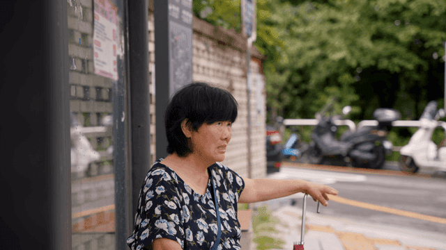 버스 정류장에 앉아 있는 노인 여성