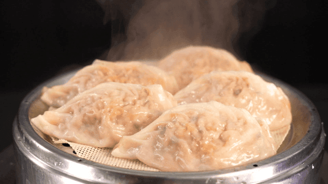 Steaming dumplings in a metal steamer
