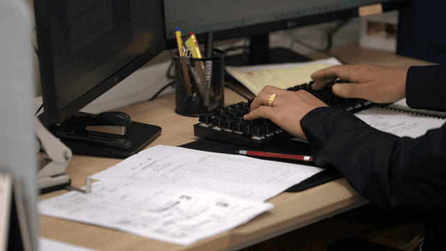 책상에서 키보드를 치는 사람