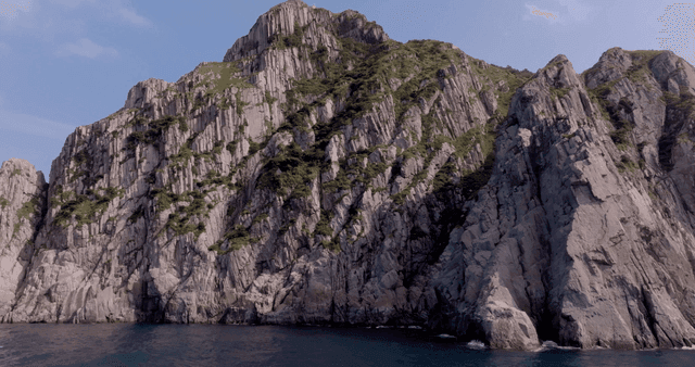 Rocky cliffs by the sea under a clear sky