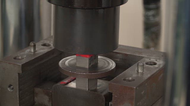 Metal being pressed in a hydraulic machine