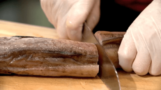 나무 도마 위에서 잘리는 명태