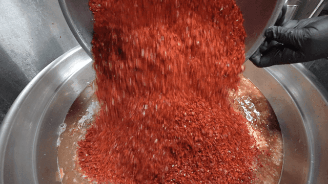 Red pepper powder being poured into basin