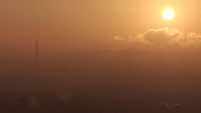 안개 낀 도시 스카이라인 위의 일몰