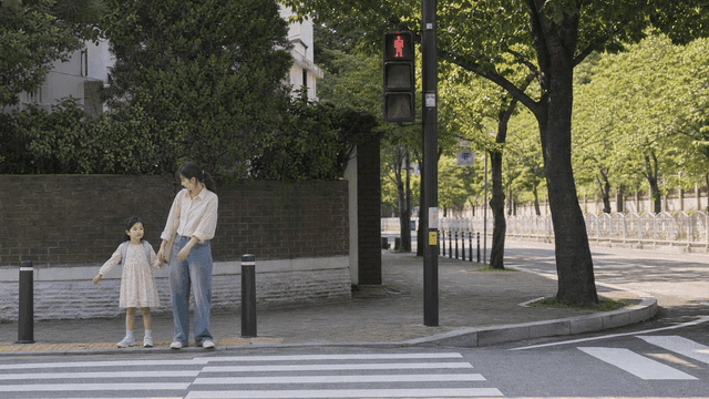Mother and daughter waiting at crosswalk