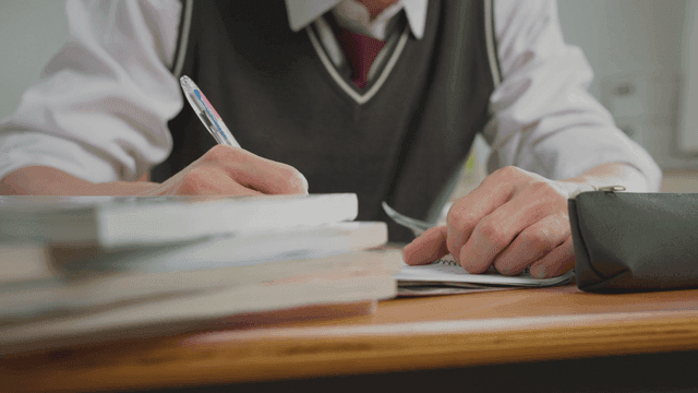 책상에서 필기하는 학생