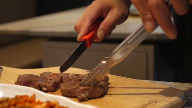 Slicing grilled steak on a cutting board