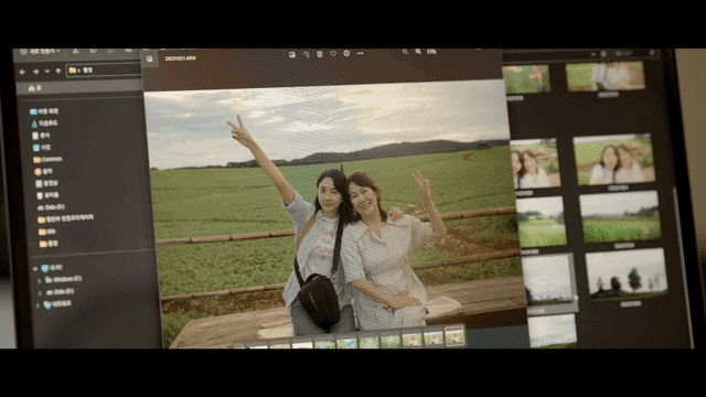 Monitor with photo of two women happily posing in field