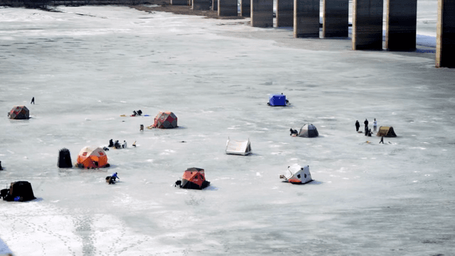 얼어붙은 호수에서 텐트를 치고 얼음 낚시하는 사람들