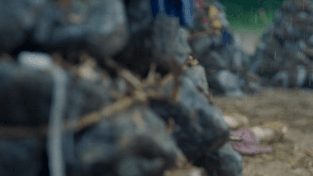 비 오는 날 쌓인 돌과 낙엽 옆으로 누워있는 발