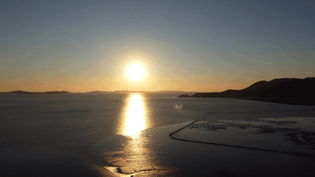 Sunset over calm sea in distance