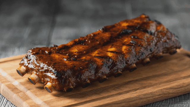 Juicy glazed ribs on a wooden board