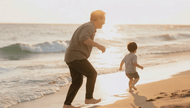 Grandfather playing with grandson on a sunset beach