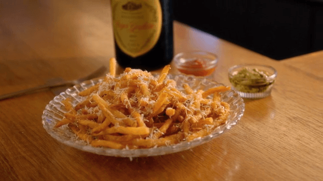 Plate of fries with cheese on a table