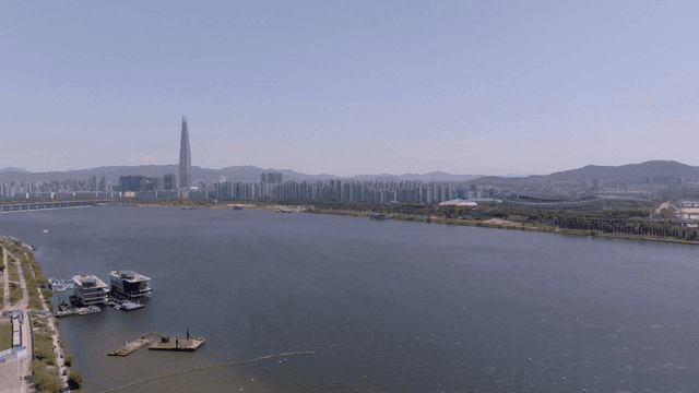 A city skyline with a river and skyscraper