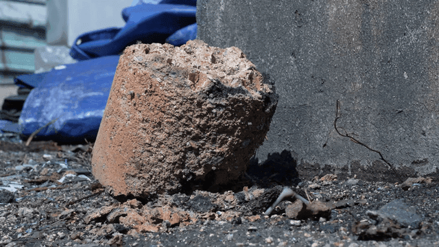 Piece of burnt coal briquette ash lying on ground