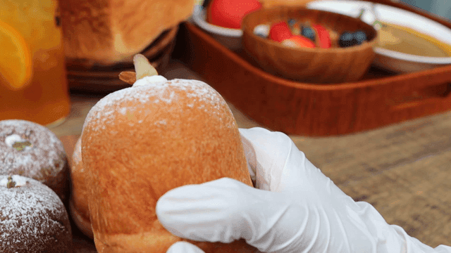 테이블 위의 빵을 들고 살피는 손