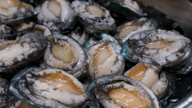Scene of pouring soju into a bowl with abalone